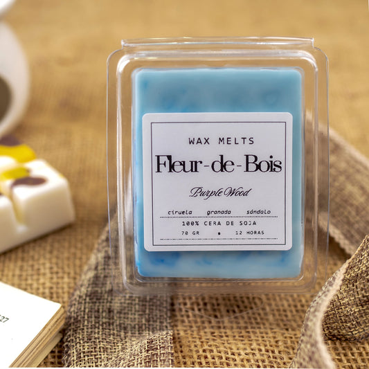 Un Wax Melts en forma de barra de chocolate PURPLE WOOD de Fleur-de-Bois, elaborada con cera de soja y perfumada con ciruela, granada y sándalo, descansa sobre arpillera, ideal como regalo personalizado.
