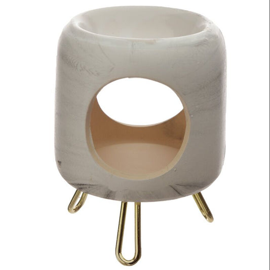 El Quemador de Cera Fundida Cerámica Fleur-de-Bois - Casa Dorada en blanco mate marmoleado en gris es un portavelas moderno con diseño cilíndrico y base de tres patas doradas, ideal para aromatizar tu hogar con estilo.