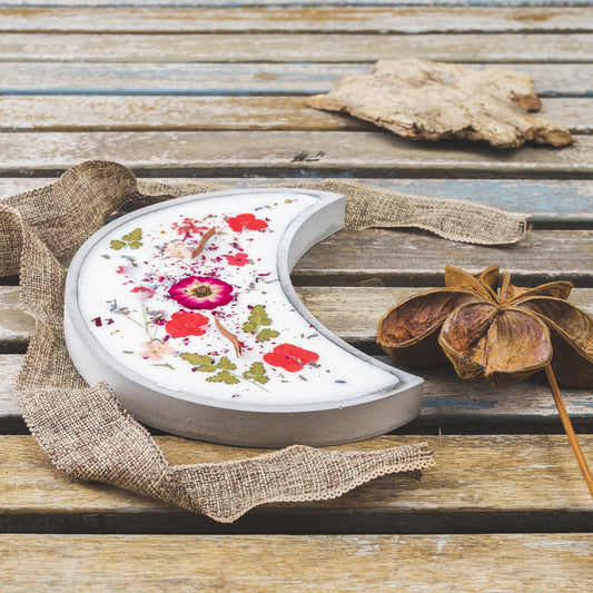 La Vela Aromática Fleur-de-Bois en Cuenco de Cemento en Forma de LUNA con Mecha Ondulada, decorada con flores y hojas prensadas sobre cera de soja blanca, es el regalo especial ideal.