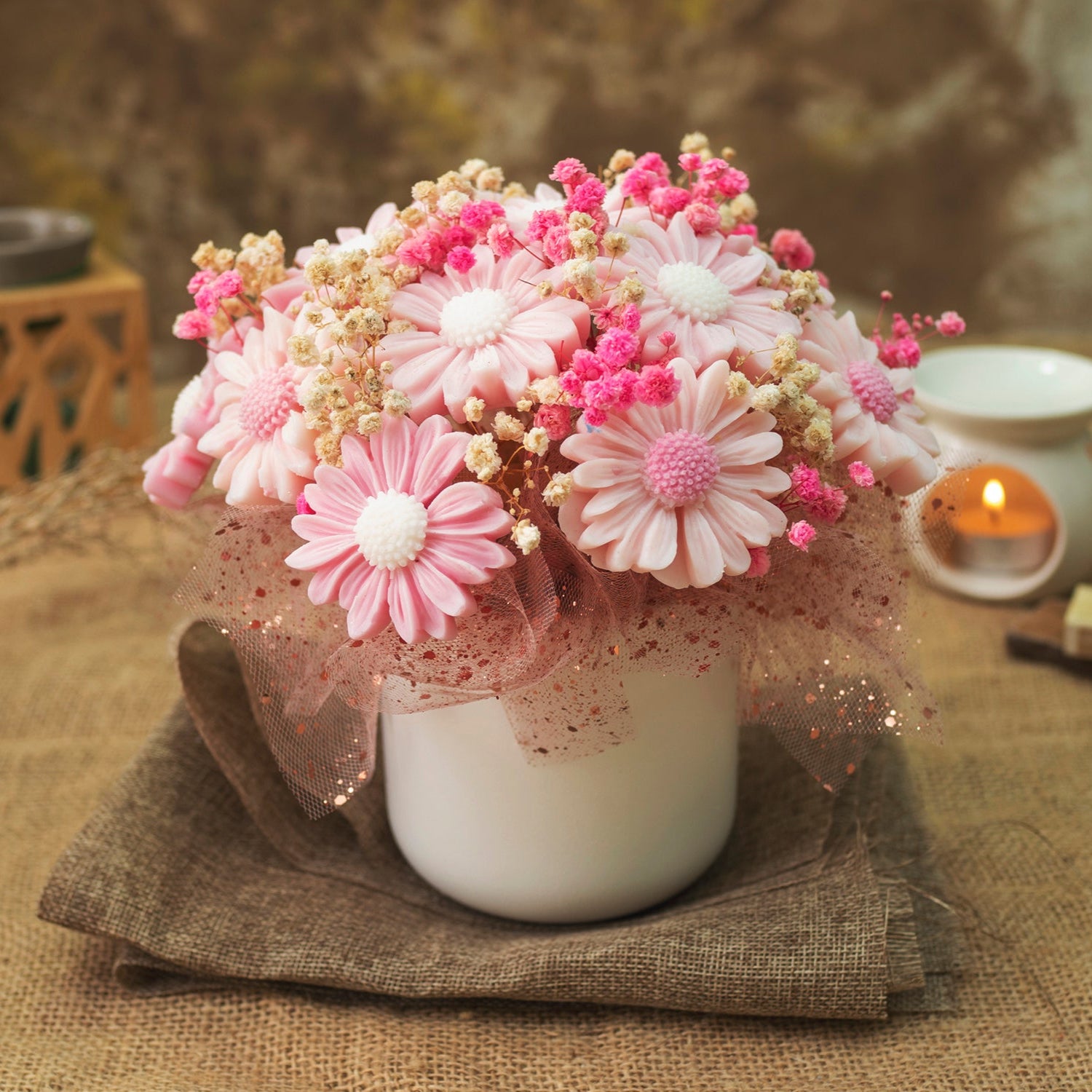 El Ramo de Flores Margaritas Clásico de Cera de Soja DULZURA DE SANDÍA de Fleur-de-Bois presenta flores rosas y blancas parecidas a margaritas con capullos rosas, envueltas en tela brillante en una taza blanca: un regalo encantador y romántico.