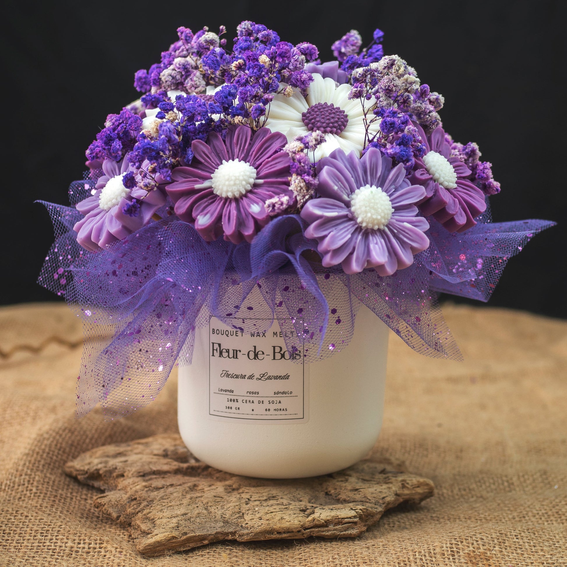 Un tarro blanco de Flor de Bois con la etiqueta "FRESCURA DE LAVANDA" contiene el Ramo de Flores Margaritas Clásico de Cera de Soja: flores artificiales moradas, blancas y lavanda con malla y purpurina, un regalo romántico ideal o un centro de mesa.