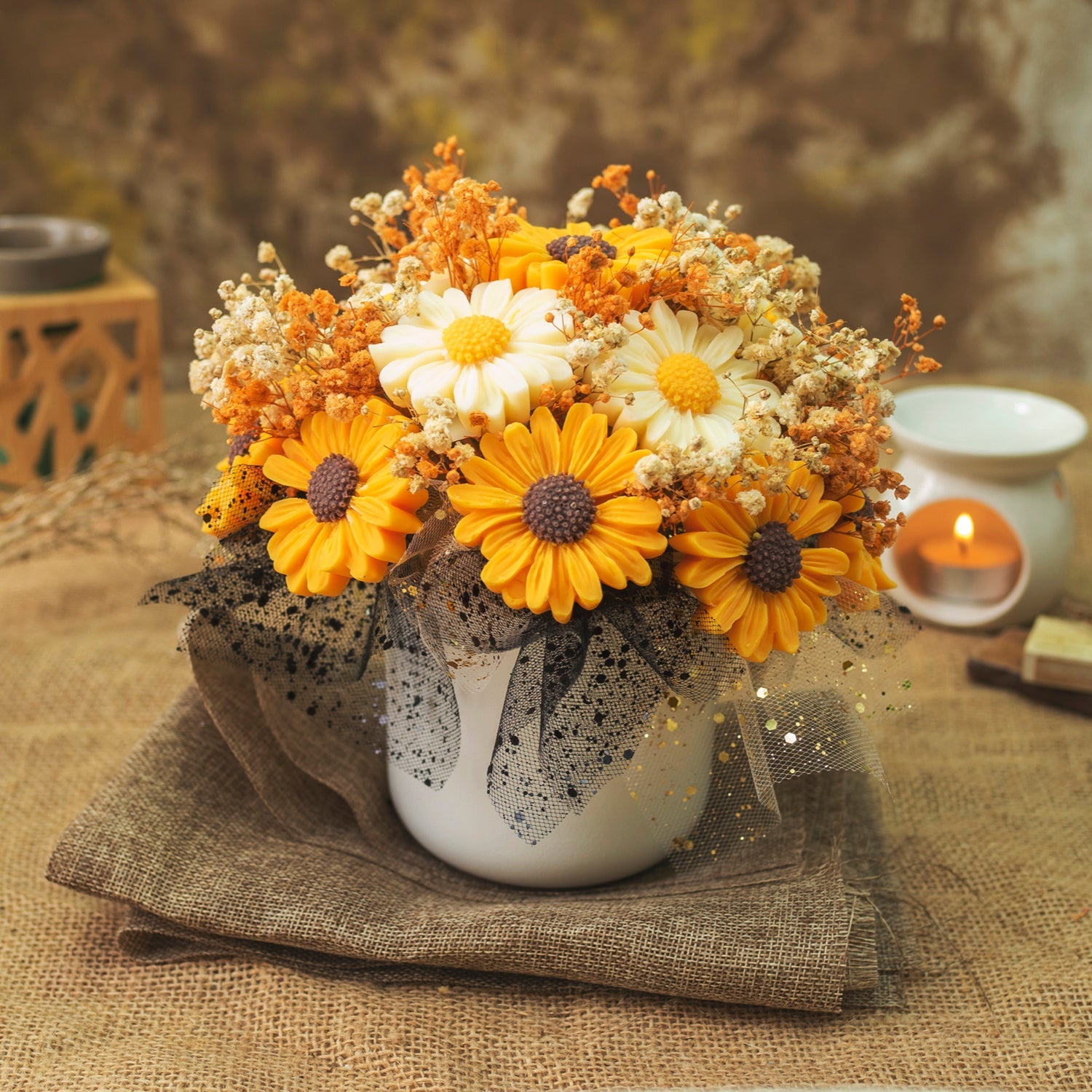 El Ramo de Flores Margaritas Clásico de Cera de Soja de Fleur-de-Bois PEAKY SPOOKY presenta margaritas artificiales amarillas, naranjas y blancas en una maceta blanca, con una vela que crea un cálido telón de fondo-ideal como regalo romántico.