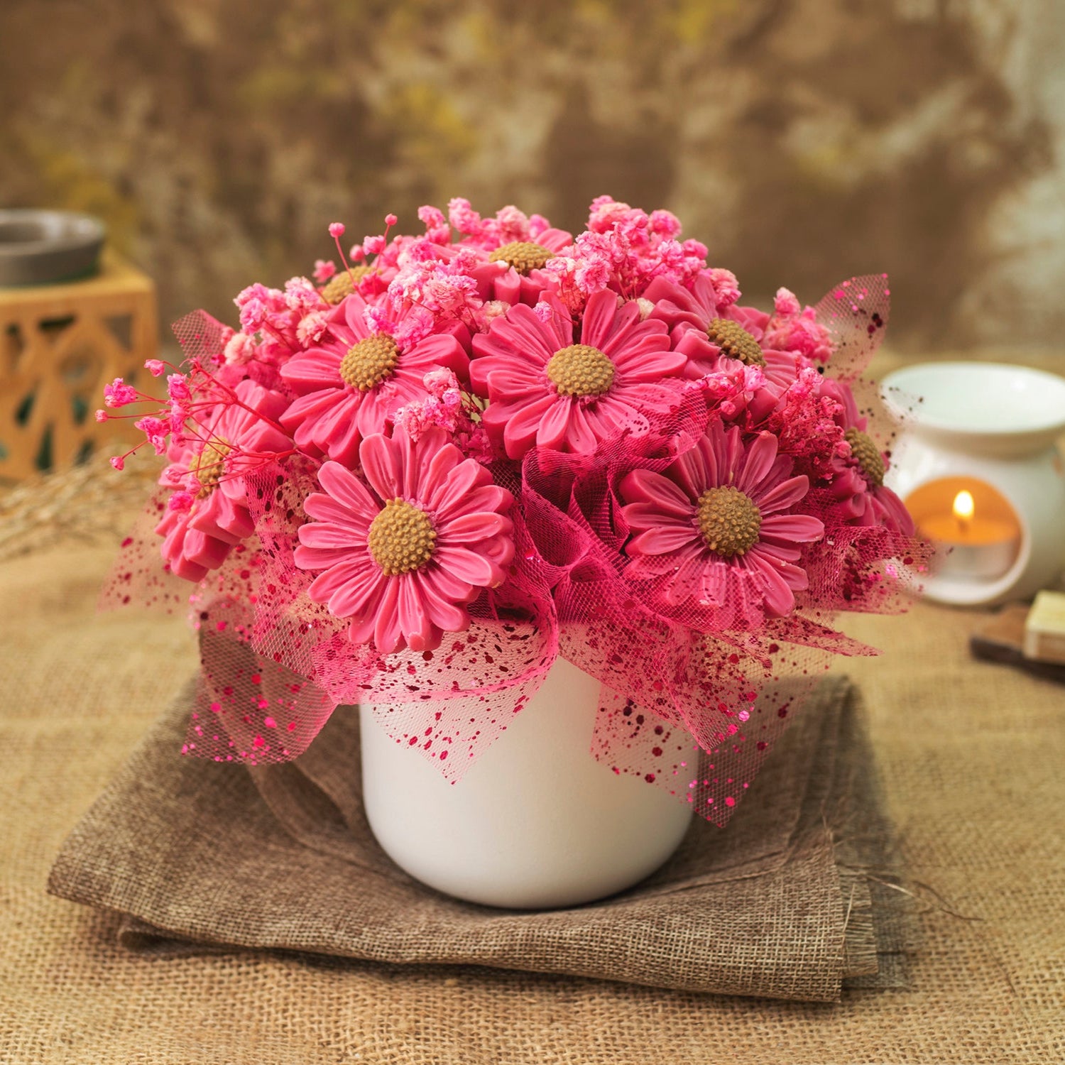 El Ramo de Flores Fleur-de-Bois Margaritas Clásico de Cera de Soja PERLA DE POMA presenta brillantes margaritas rosas y acentos en una maceta de cerámica blanca, arregladas con red rosa-un regalo encantador y romántico.