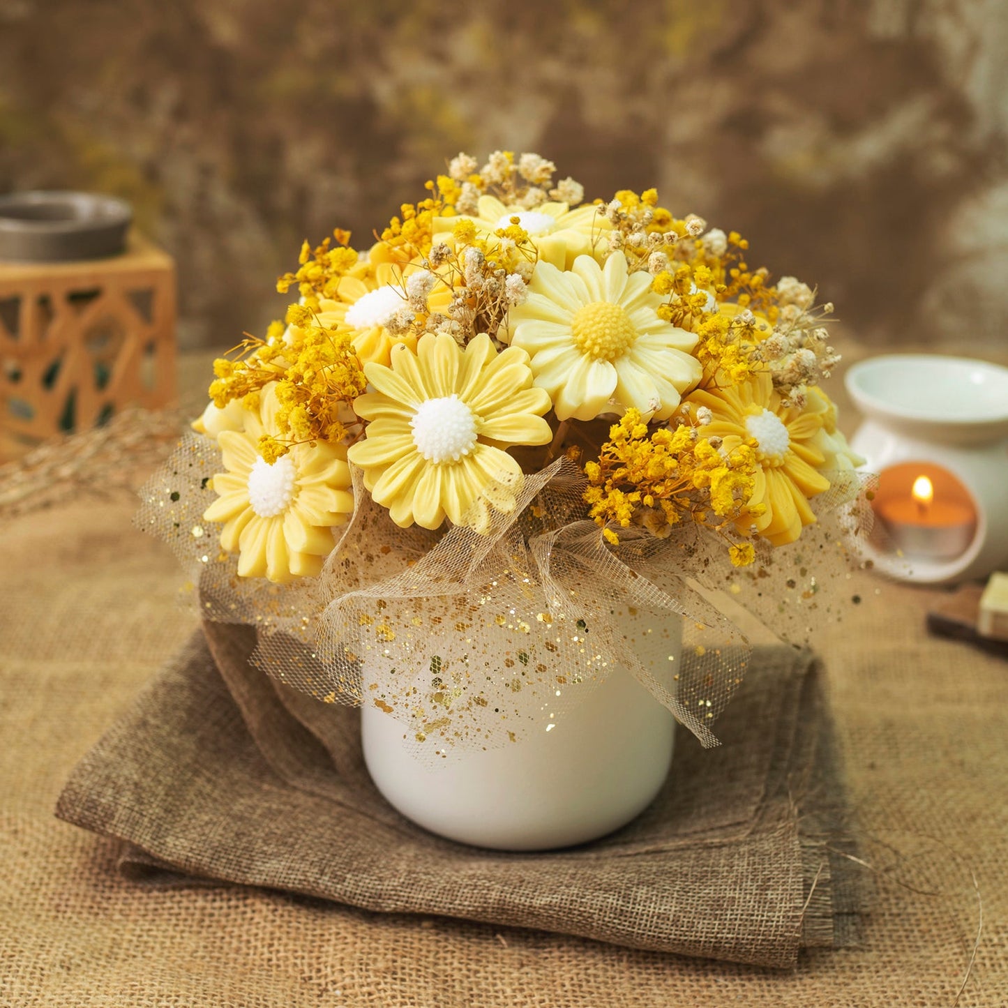 El Ramo de Flores Margaritas de Cera de Soja PIE DE LIMÓN de Fleur-de-Bois combina margaritas blancas y amarillas con pequeños toques dorados, envuelto en malla decorativa dorada, ideal como regalo romántico y elegante.