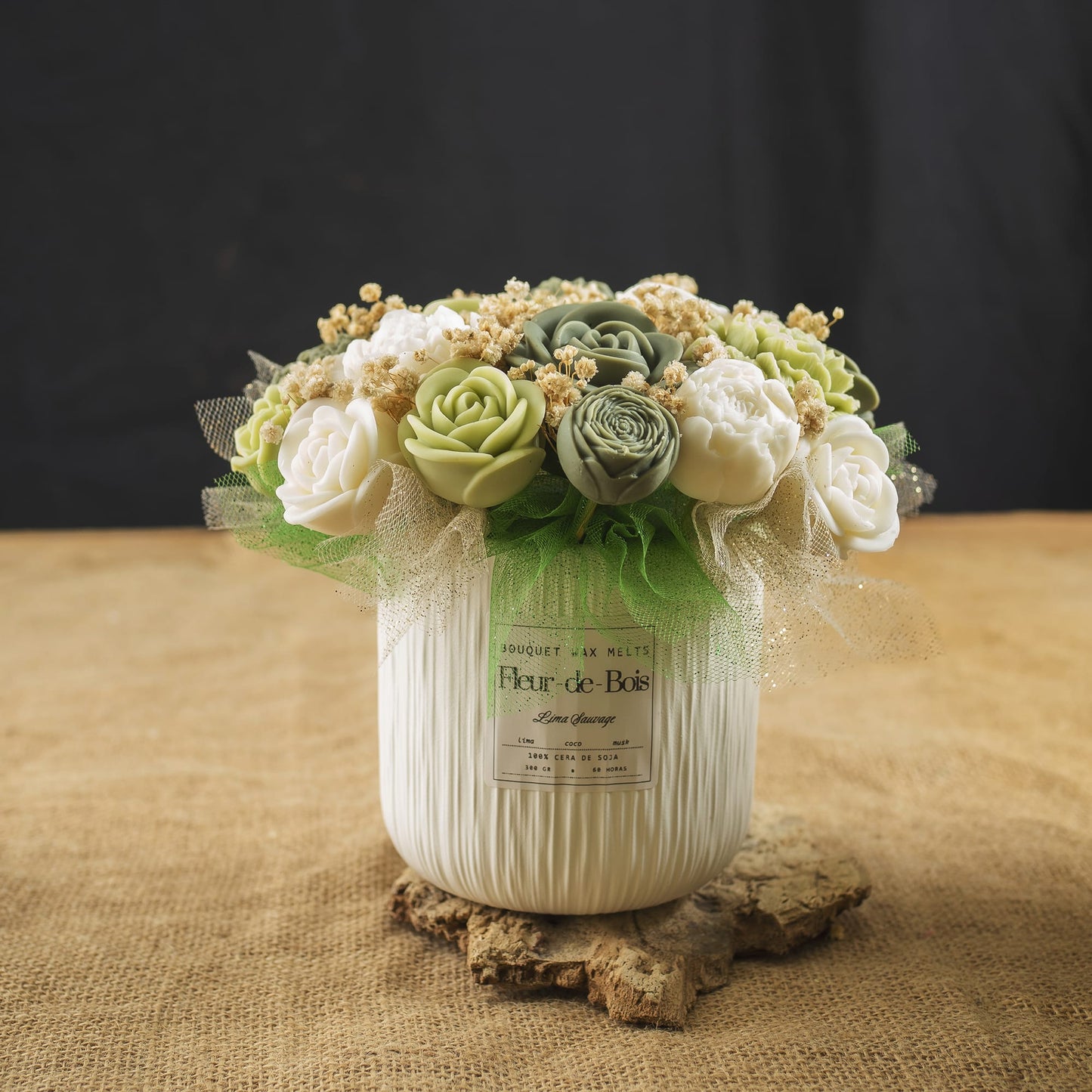 El ramo «Fleur-de-Bois» de peonías y rosas clásico de cera de soja «LIMA SAUVAGE» cuenta con flores artificiales verdes y blancas, además de detalles secos en color beige, dispuestas en un jarrón blanco decorativo sobre arpillera, con un fondo oscuro.