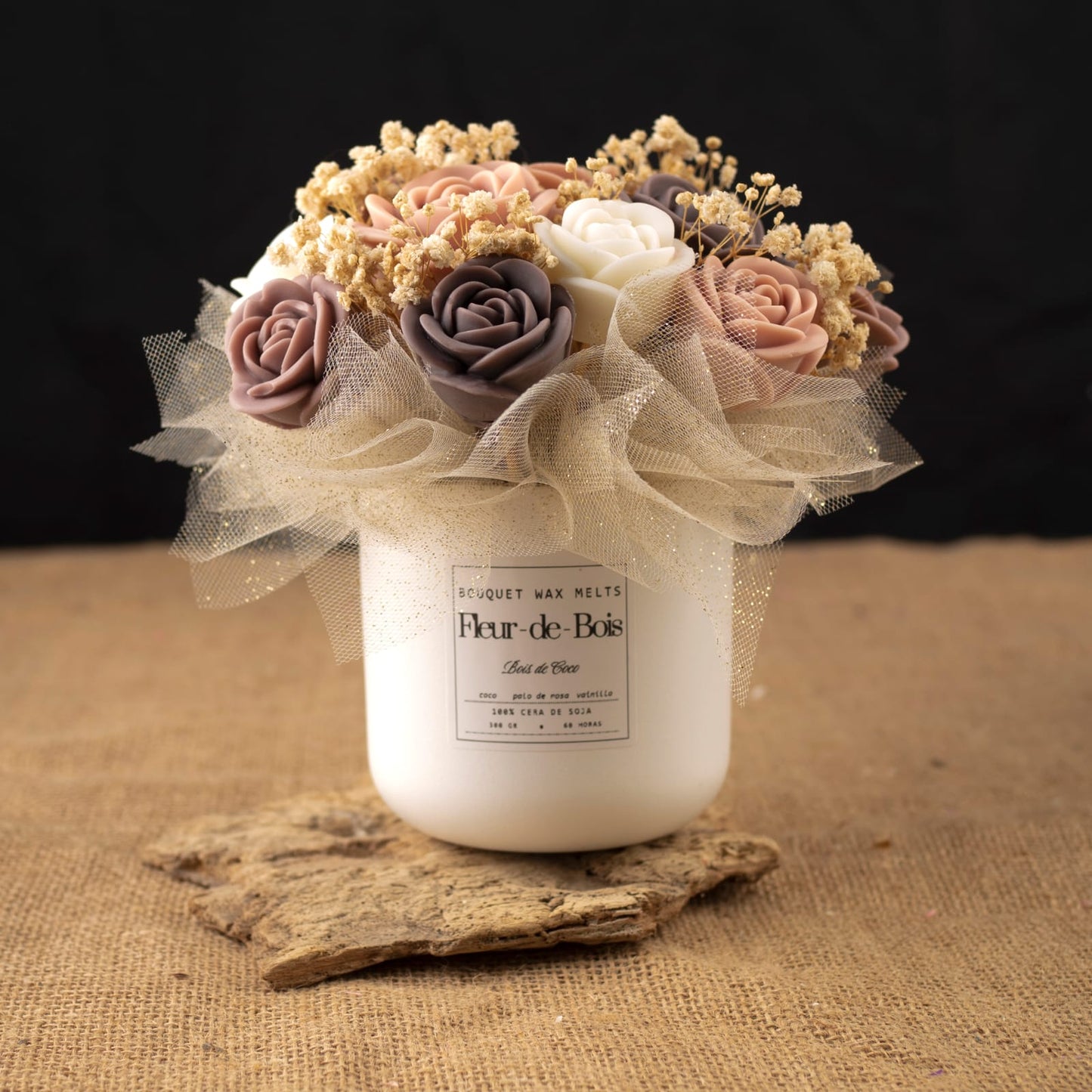 Un tarro blanco Fleur-de-Bois con la etiqueta "BOIS DE COCO" exhibe el Ramo de Rosas Clásico de Cera de Soja: rosas de cera de color crema, rosa y malva con flores secas y una cinta beige, un encantador y romántico conjunto de regalo sobre arpillera y madera.