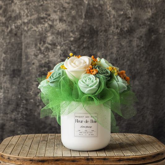 El Ramo de Rosas Clásico de Cera de Soja LIMA SAUVAGE Fleur-de-Bois -rosas artificiales de color verde pálido y blanco con toques naranjas- se presenta en un jarrón blanco, ideal como regalo romántico sobre cualquier superficie de madera.