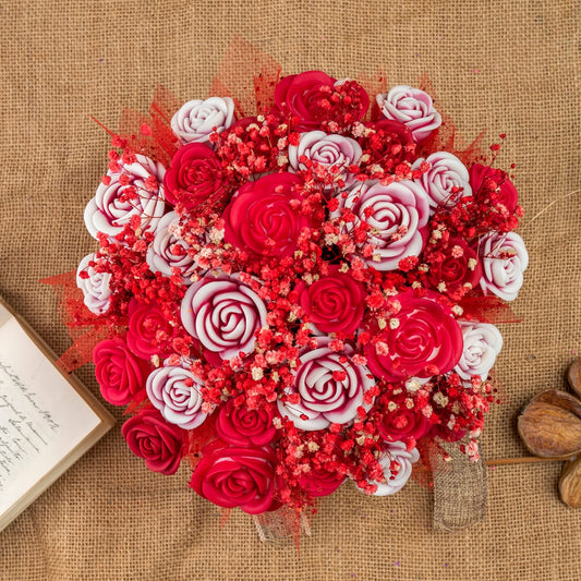 El Ramo de Rosas GRANDE de Cera de Soja de Fleur-de-Bois presenta un ramo circular de rosas rojas y blancas con toques rosas, dispuesto sobre arpillera con un cuaderno abierto, piedras marrones y velas de cera de soja, ideal como regalo romántico.